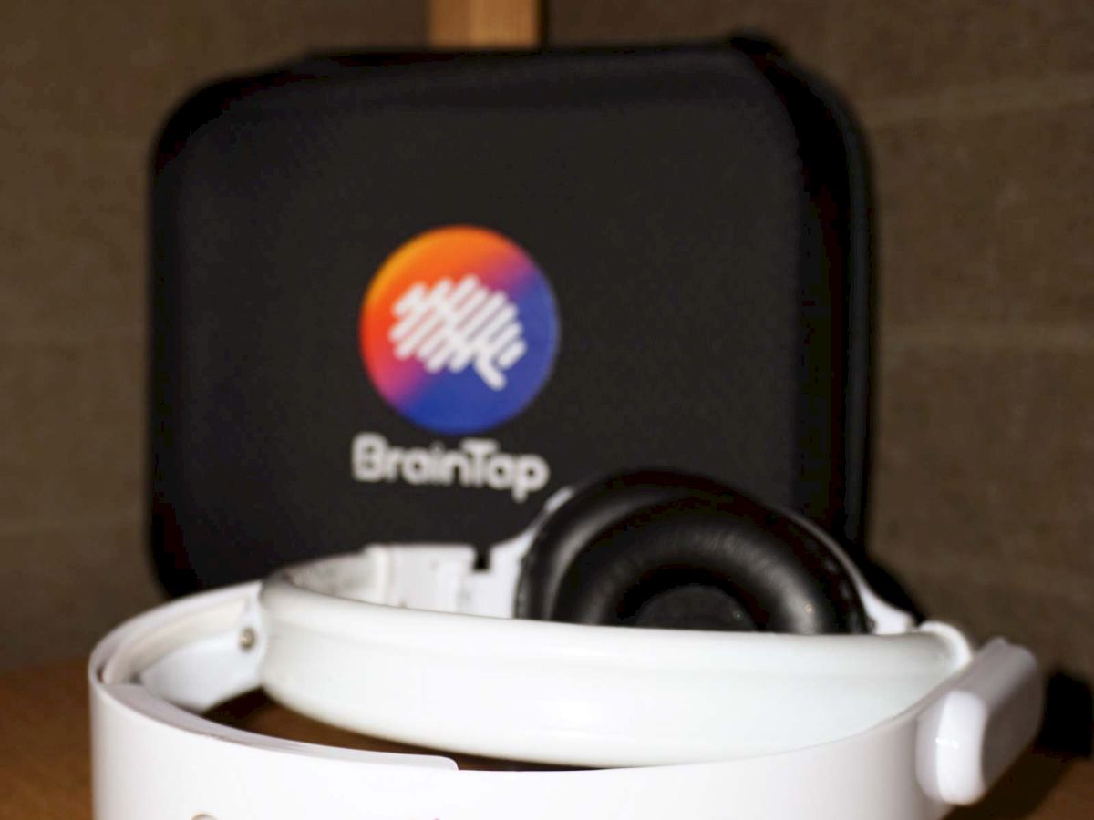 A BrainTap branded smart meditation device/dock in a cup with the BrainTap logo on the front.