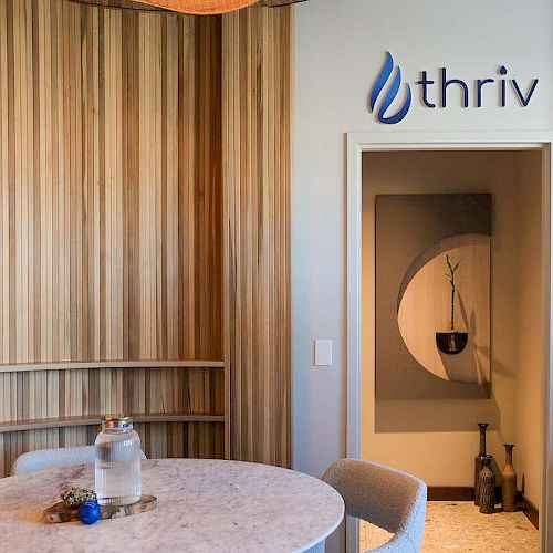 A modern interior shows a marble table, wooden walls, and an &ldquo;IBM&rdquo; logo on a white sign above a doorway.