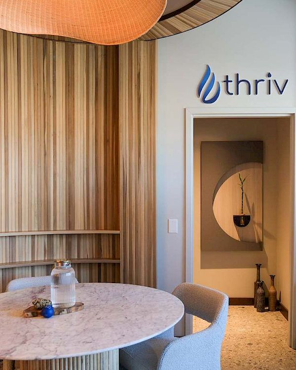 A modern interior shows a marble table, wooden walls, and an &ldquo;IBM&rdquo; logo on a white sign above a doorway.