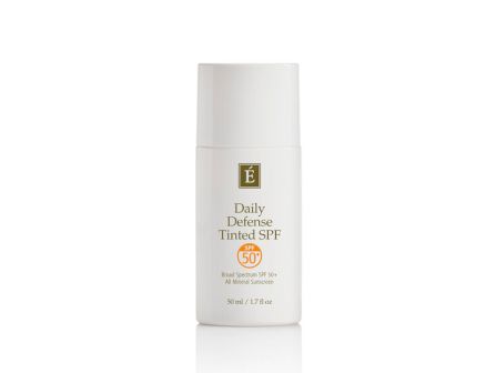 A bottle of &Eacute; Daily Defense Tinted SPF sunscreen (SPF 50) with a gold label.