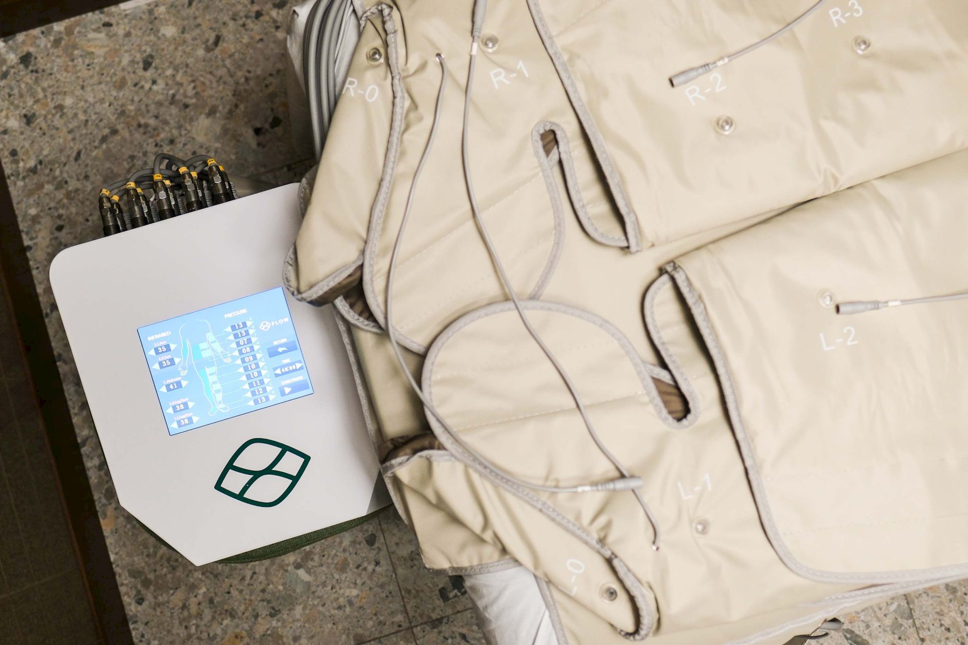 A medical therapy unit shows a body suit with numbered tubing and sensors, plus a control screen displaying pressure/flow readings and an infrared map.
